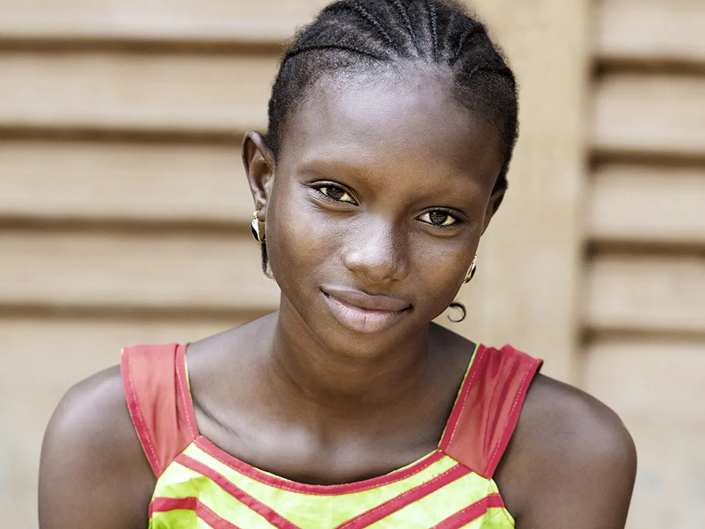 A teenage girl from Africa smiles at the camera.