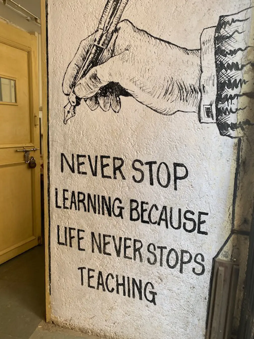 A painted sign that says "Never Stop Learning Because Life Never Stops Teaching."