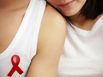 Two women wearing HIV awareness ribbons