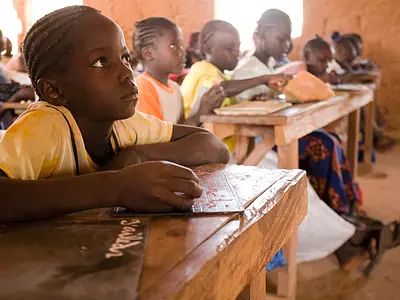 An elementary-age girl attends a reading class in Senegal.