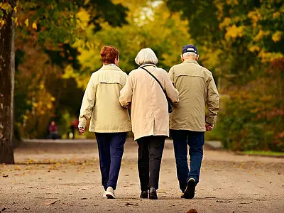 Three elderly people walking
