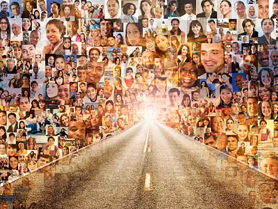 Conceptual image of a long road with individual smiling faces surrounding it