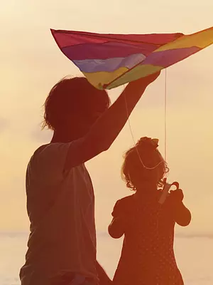 father and daughter flying a kite