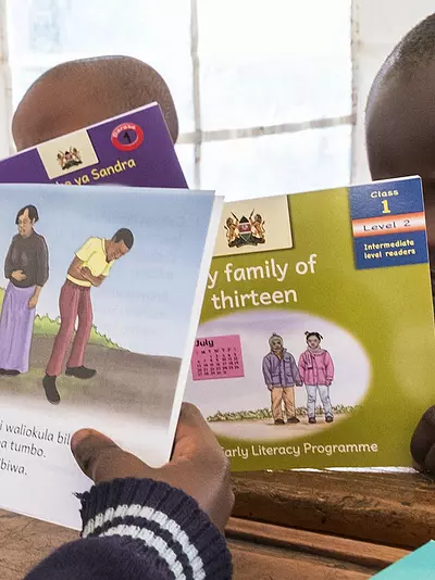 Children read books produced by RTI for international literacy programs.