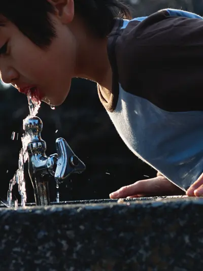 Child drinks from water fountain