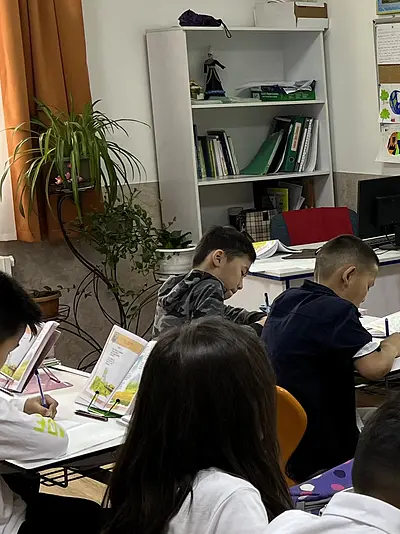 Students take notes while listening to a teacher in the Kyrgyz Republic.