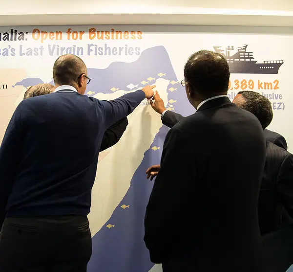 Seafood industry leaders check out a map of Somalia's fisheries.