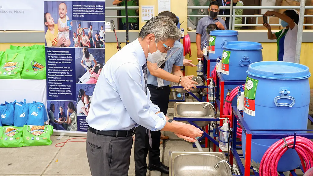 U.S. Ambassador Sung Kim uses one of the 16 handwashing stations installed in facilities and communities around the city.