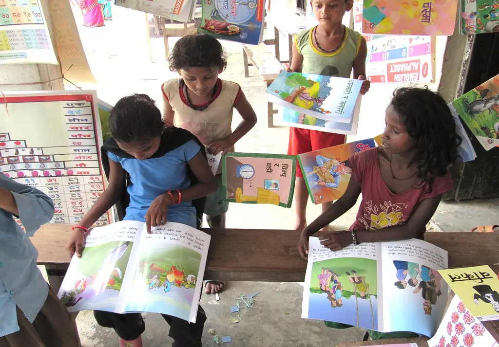 Schoolchildren read books printed in their native languages from the Nepal EGRP.