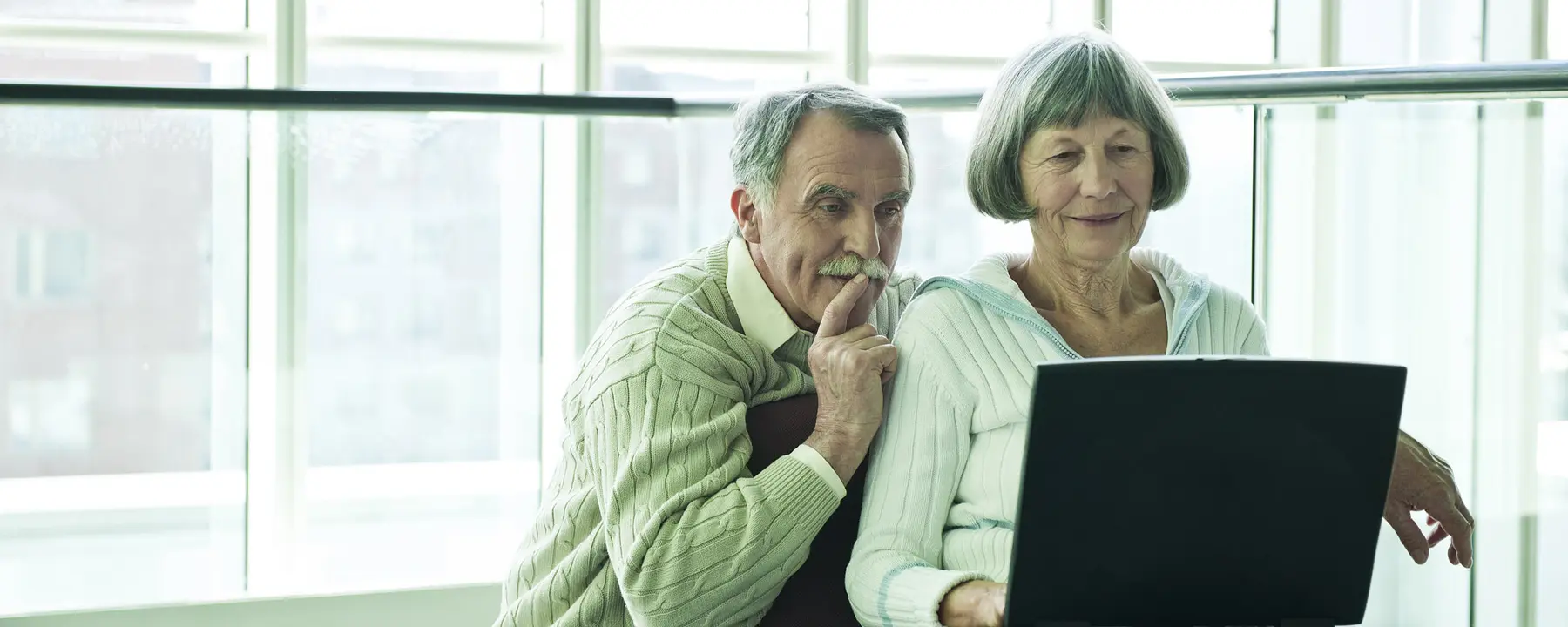 older couple looking at information on a laptop