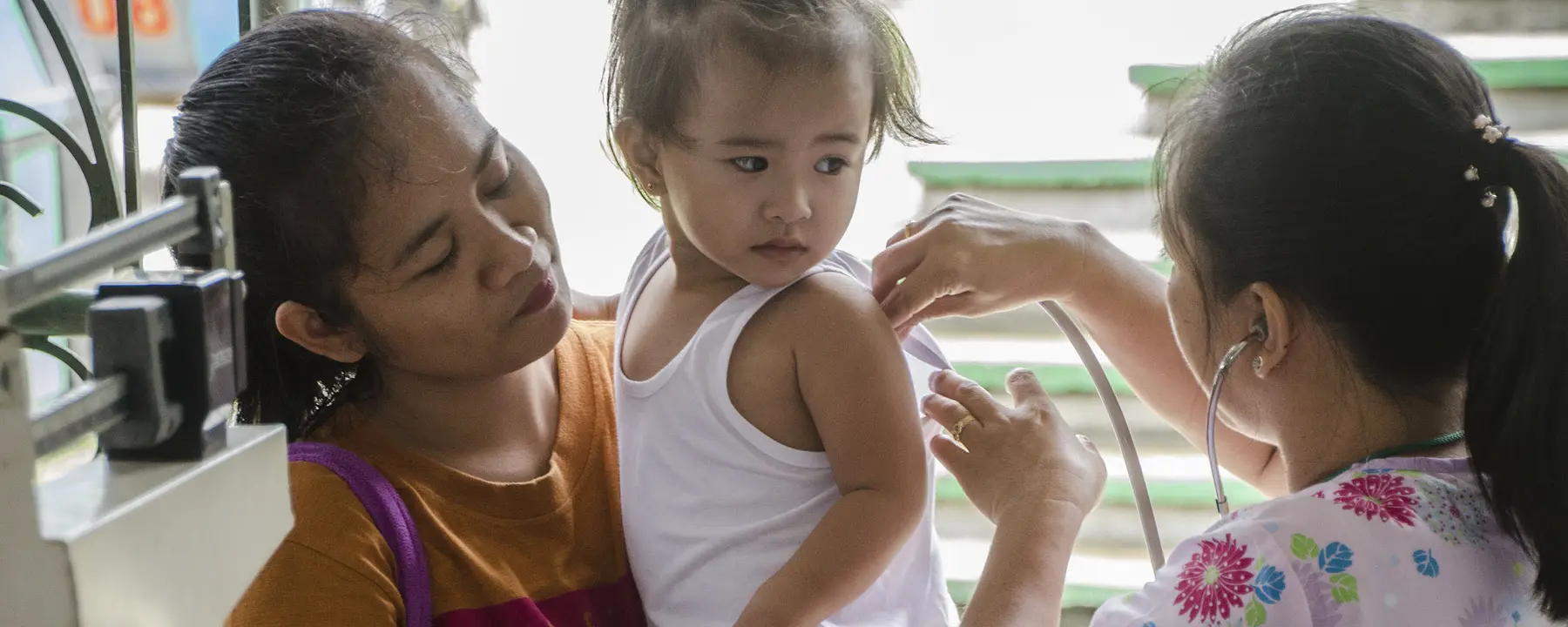 Filipino doctor measures a young patient