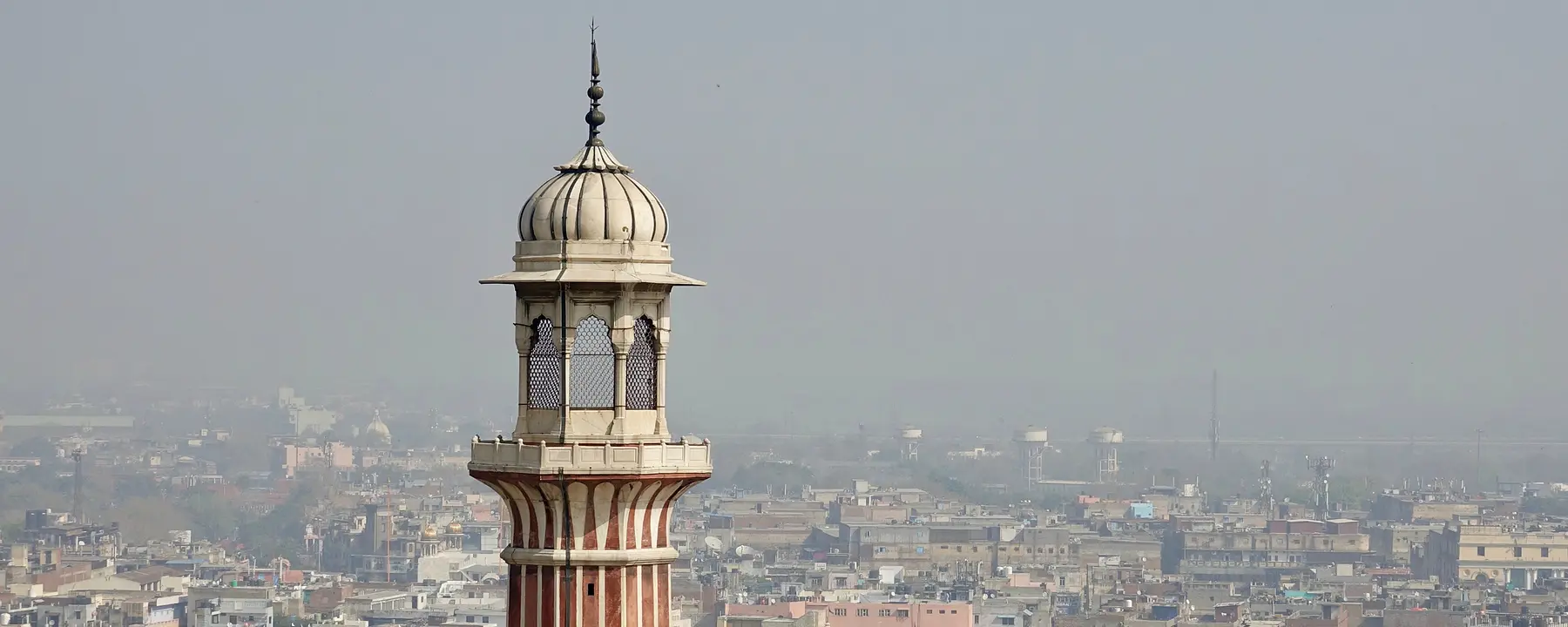 Hazy skies surround a minaret over the old section of Delhi, India.