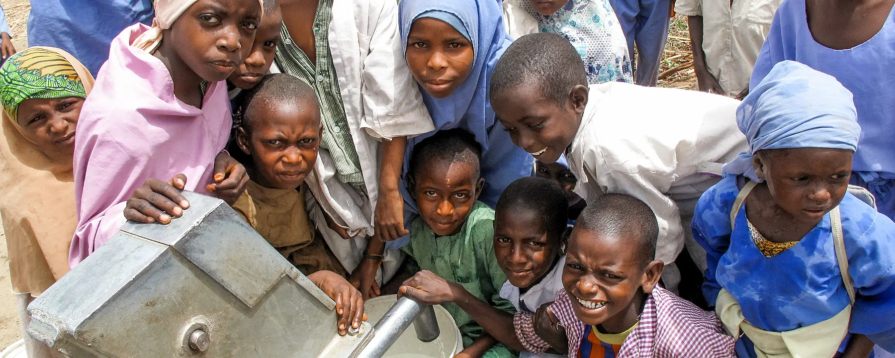 Children gather around new water borehole in Nigeria