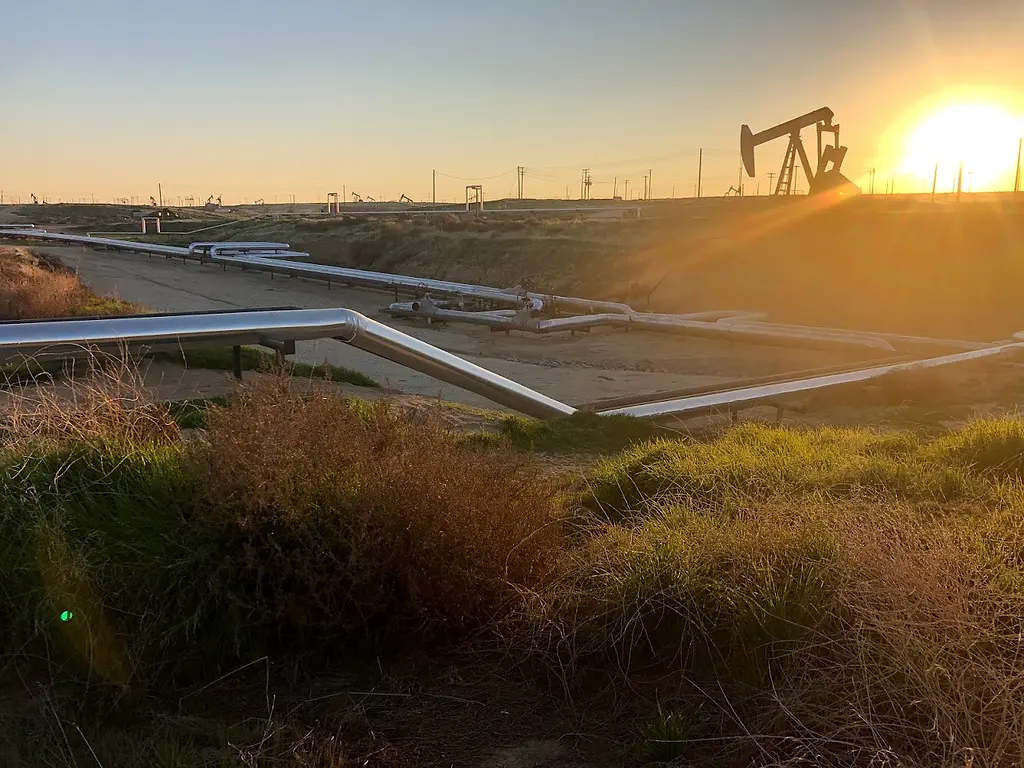 A pipeline runs across oil fields.