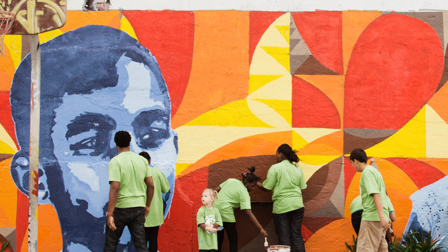 People collaborate on a mural