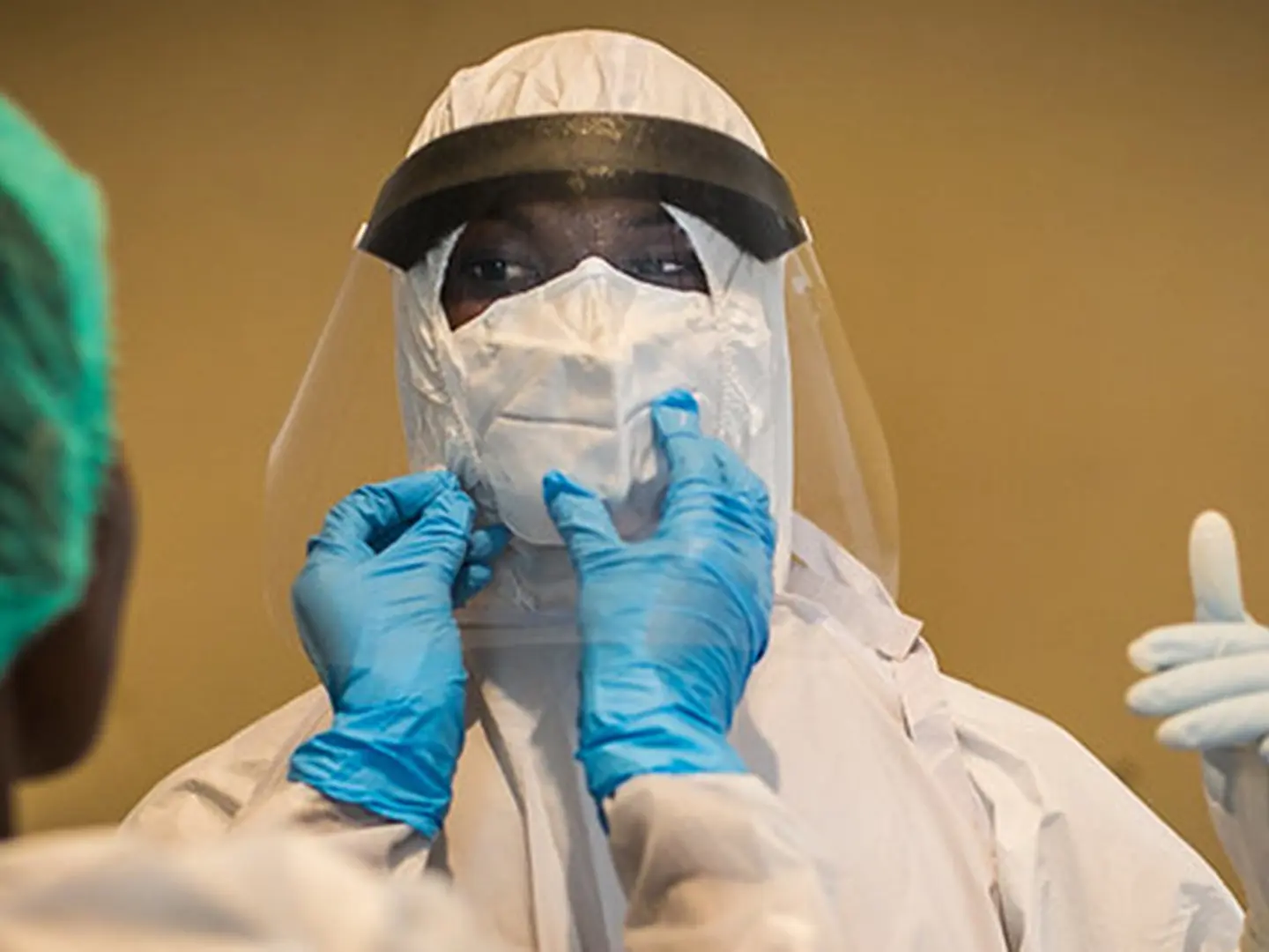 African medical workers dress in protective gear.
