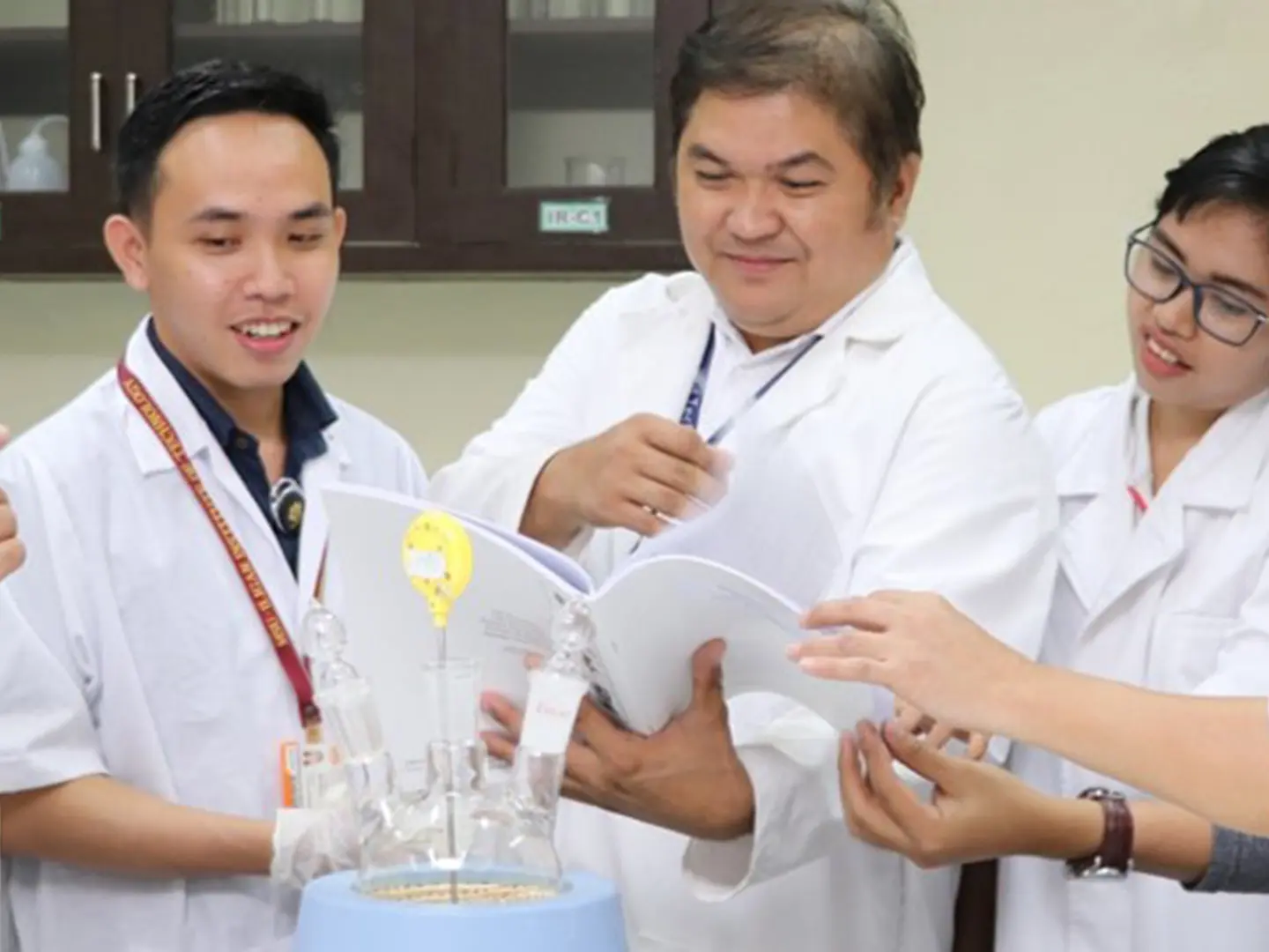 A group of students work with an instructor at a university lab in the Philippines.