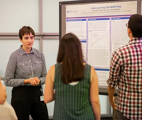 Data Science intern Caroline Kerry explains her research to visitors at the Internship Showcase.