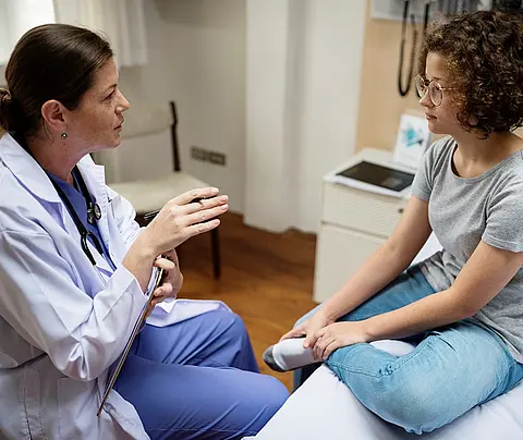 Doctor speaks to teen patient