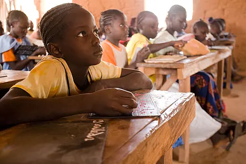 An elementary-age girl attends a reading class in Senegal.
