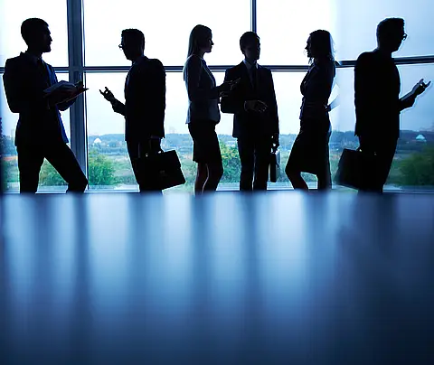 Silhouette of business people standing by a window