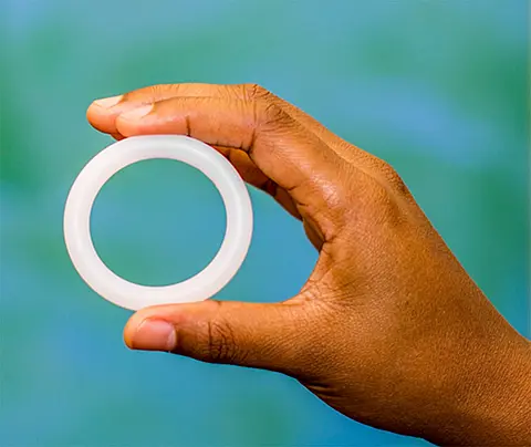 A hand holding a vaginal ring, which can be used to deliver contraceptives, HIV preventatives, and other drugs.